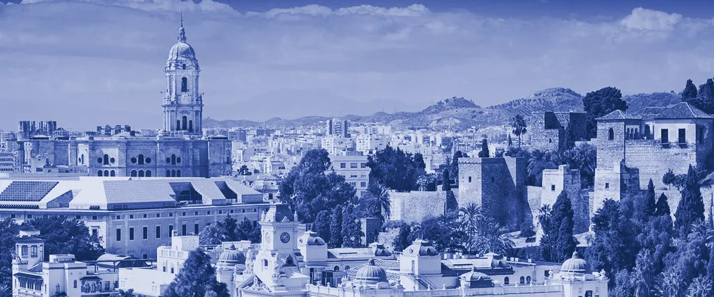 Panorámica de la ciudad de Málaga con la catedral y el puerto, en duotono azul tinta